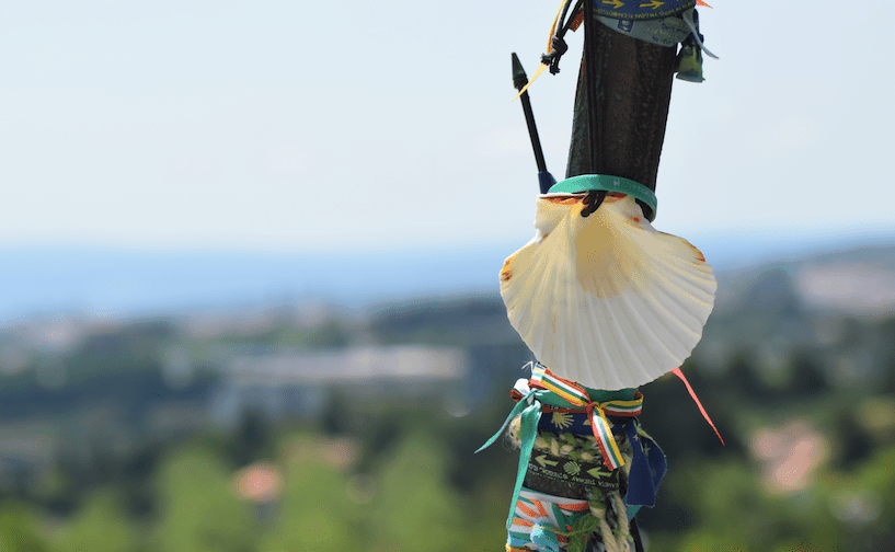 Scallop Shell on the walking stick with blurry landscape