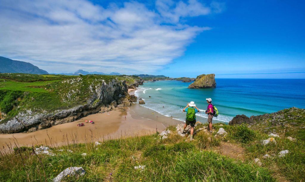 pilgrims on the camino del norte looking at san martin beach