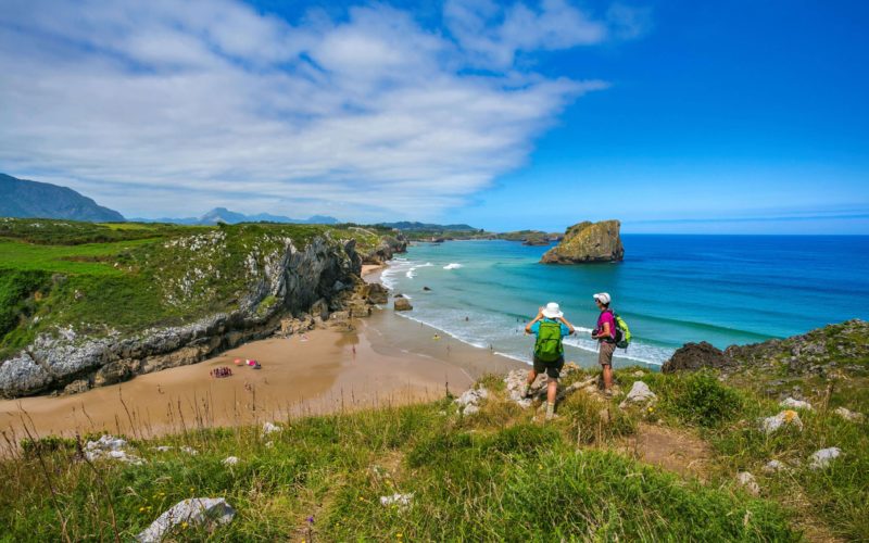 pilgrims on the camino del norte looking at san martin beach